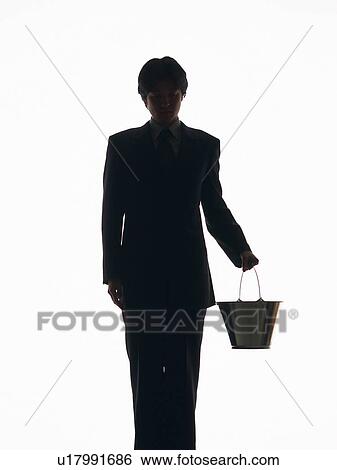 Stock Photograph - Bsinessman standing and holding bucket, Front View, Silhouette . Fotosearch