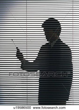 Bsinessman standing and using mobile phone by the blind, Side View, Silhouette View Large Photo Image Stock Image - Bsinessman standing and using mobile phone by the blind, Side View, Silhouette . Fotosearch
