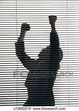 Bsinessman standing by the blind with both fists up in the air, Side View, Silhouette View Large Photo Image Stock Photo - Bsinessman standing by the blind with both fists up in the air, Side View, Silhouette . Fotosearch