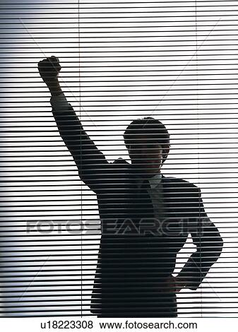 Stock Photo - Bsinessman standing by the blind with fist up in the air, Front View, Silhouette . Fotosearch