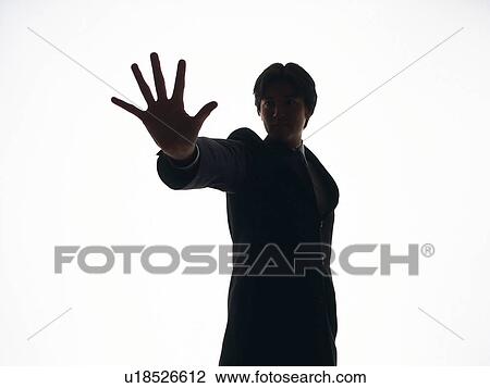 Stock Image - Bsinessman standing with palm up in the air, Front View, Silhouette . Fotosearch