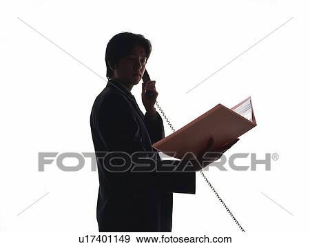 Bsinessman talking on the phone with documents, Side View, Silhouette  View Large Photo Image Stock Photo - Bsinessman talking on the phone with documents, Side View, Silhouette . Fotosearch