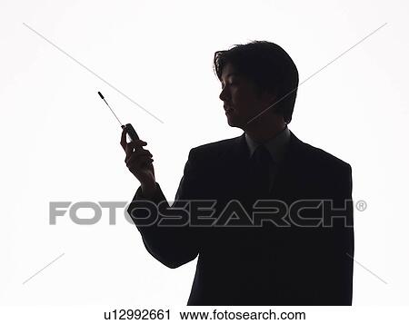 Stock Image - Bsinessman using mobile phone, Side View, Silhouette . Fotosearch