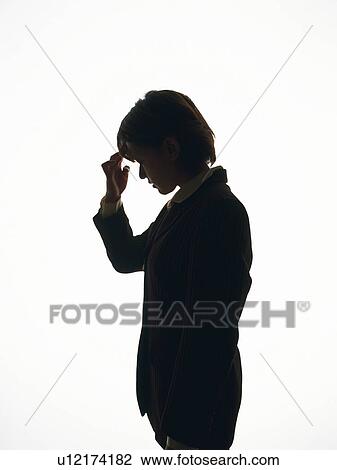 Stock Image - Bsinesswoman standing and being troubled, Side View, Silhouette . Fotosearch
