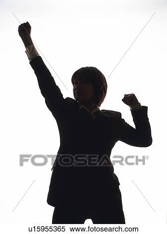 Stock Photography - Bsinesswoman standing and raising fist up in the air, Front View, Silhouette . Fotosearch