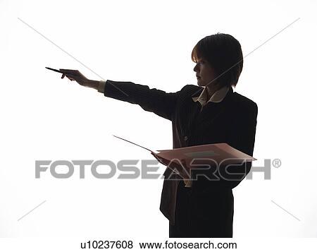 Stock Photo - Bsinesswoman standing with documents and pointing away with a pen, Side View, Silhouette . Fotosearch