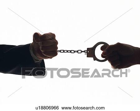 Stock Photograph - Hand pulling the hand in handcuffs, Silhouette. Fotosearch