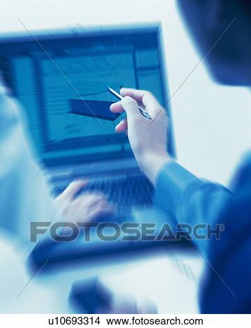 Picture - Businessman and businesswoman working with a computer at the desk, Portrait, Rear View, Toned Image, Blurred Motion. Fotosearch