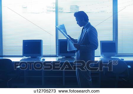 Businessman reading news paper by the desk, Portrait, Side View, Toned Image View Large Photo Image Stock Image - Businessman reading news paper by the desk, Portrait, Side View, Toned Image. Fotosearch