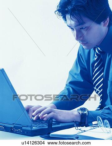 Businessman working with a computer at the desk, Portrait, Side View, Toned Image View Large Photo Image Picture - Businessman working with a computer at the desk, Portrait, Side View, Toned Image. Fotosearch