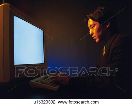 Businessman working with a computer at the desk, Portrait, Side View, Toned Image View Large Photo Image Stock Image - Businessman working with a computer at the desk, Portrait, Side View, Toned Image. Fotosearch