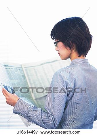 Stock Photo - Businesswoman reading news paper, Portrait, Rear View, High Key. Fotosearch