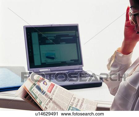 Businesswoman sitting and reading news paper at the desk, Portrait, Side View View Large Photo Image Stock Image - Businesswoman sitting and reading news paper at the desk, Portrait, Side View. Fotosearch