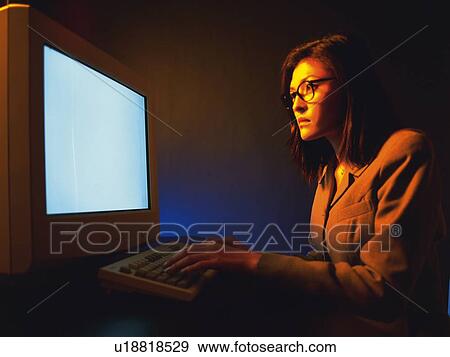 Stock Photo - Businesswoman working with a computer at the desk, Portrait, Side View, Toned Image. Fotosearch