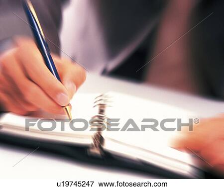 Stock Photo - Hand writing down on a scheduler, Close Up, Blurred Motion. Fotosearch