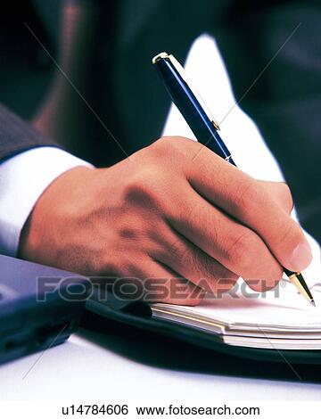 Stock Photograph - Hand writing down on a scheduler, Close Up, Toned Image. Fotosearch