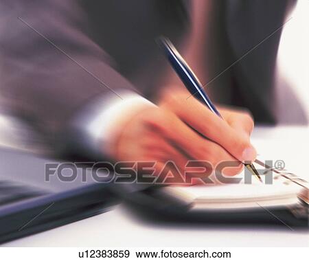 Stock Photo - Hand writing down on a scheduler, Blurred Motion. Fotosearch