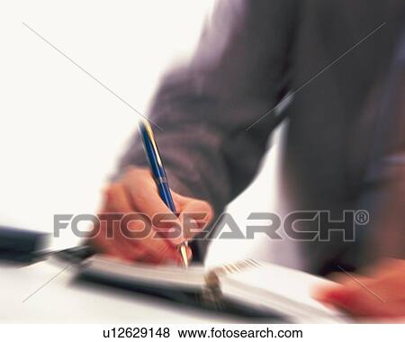 Stock Photo - Hand writing down on a scheduler, Blurred Motion. Fotosearch