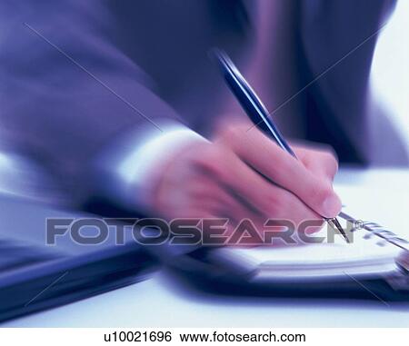 Stock Photograph - Hand writing down on a scheduler, Toned Image, Blurred Motion. Fotosearch