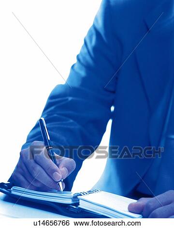 Stock Photograph - Hand writing down on a scheduler, Toned Image. Fotosearch