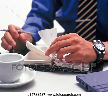 Stock Photo - Hands flipping the pages of the scheduler, High Angle View. Fotosearch