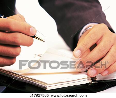 Stock Photography - Hands flipping the pages of the scheduler, Close Up. Fotosearch