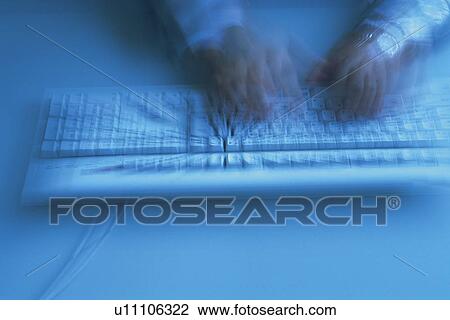 Stock Image - Hands typing keyboard, High Angle View, Blurred Motion. Fotosearch