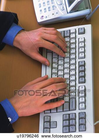 Stock Photograph - Hands typing keyboard, High Angle View. Fotosearch
