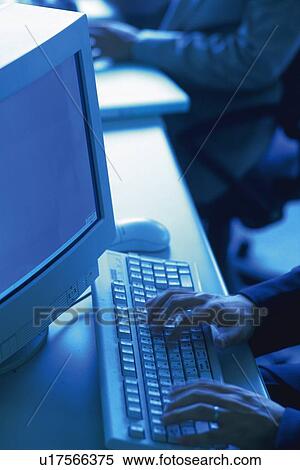 Stock Photography - Hands working with a computer at the desk, High Angle View, Toned Image. Fotosearch