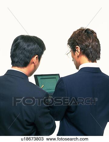 Two businessmen working with a computer at the desk, Portrait, Rear View, High Angle View View Large Photo Image Stock Image - Two businessmen working with a computer at the desk, Portrait, Rear View, High Angle View. Fotosearch