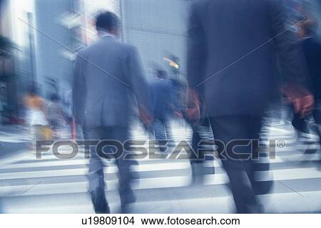 Picture - Business people crossing at the crosswalk, rear view, blurred motion, Tokyo, Japan. Fotosearch