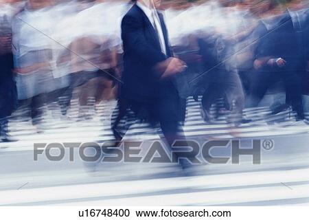 Stock Image - Business people crossing at the crosswalk, blurred motion, Tokyo, Japan. Fotosearch