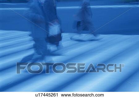Stock Image - Business people crossing at the crosswalk, side view, blurred motion, Tokyo, Japan. Fotosearch