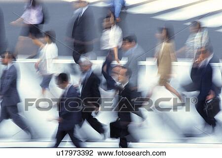 Stock Image - Business people crossing at the crosswalk, high angle view, blurred motion, Tokyo, Japan. Fotosearch