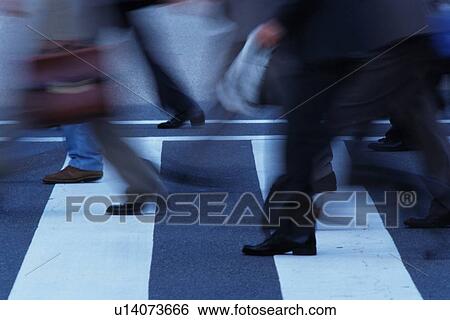 Stock Photograph - Business people crossing at the crosswalk, side view, Tokyo, Japan. Fotosearch