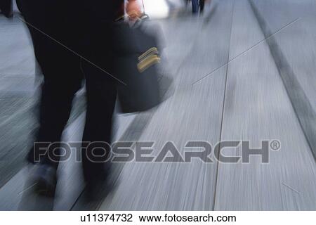 Businessman walking and holding bag, rear view, blurred motion, Tokyo, Japan View Large Photo Image Stock Image - Businessman walking and holding bag, rear view, blurred motion, Tokyo, Japan. Fotosearch