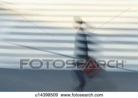 Stock Photo - Businessman walking at the crosswalk, side view, blurred motion, Tokyo, Japan. Fotosearch