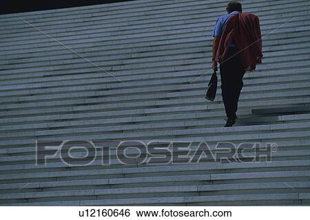 Stock Photograph - Businessman walking up stairs, low angle view, Tokyo, Japan. Fotosearch