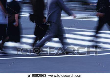 Stock Image - People crossing at the crosswalk, side view, blurred motion, Tokyo, Japan. Fotosearch