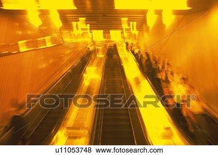 Stock Photo - People riding escalators, low angle view, blurred motion, Tokyo, Japan. Fotosearch
