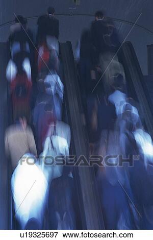 Stock Photo - People riding escalators, low angle view, blurred motion, Tokyo, Japan. Fotosearch