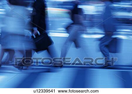 Stock Image - People walking at the crosswalk, side view, blurred motion, toned image, Tokyo, Japan. Fotosearch