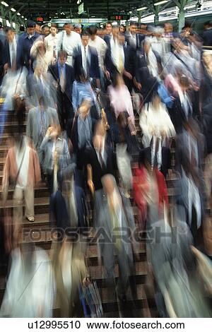 Stock Image - People walking down stairs at station, high angle view, blurred motion, Tokyo, Japan. Fotosearch