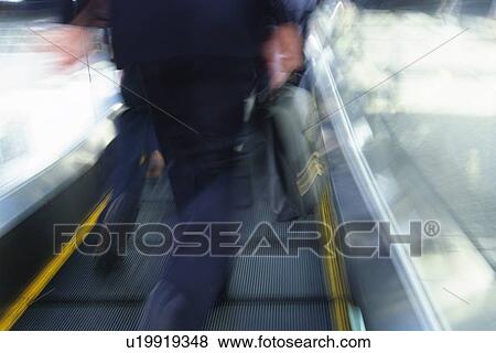 People walking down the moving walkway, rear view, blurred motion, Tokyo, Japan View Large Photo Image Stock Photo - People walking down the moving walkway, rear view, blurred motion, Tokyo, Japan. Fotosearch