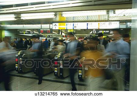 Stock Photography - People walking through automatic ticket wicket at station, blurred motion, Tokyo, Japan. Fotosearch