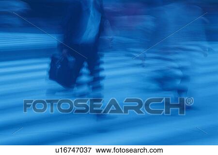 Stock Photo - Two men running at the crosswalk, toned image, blurred motion, Tokyo, Japan. Fotosearch