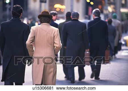 Stock Image - Business people walking down on street, rear view, New York City, NY, USA. Fotosearch