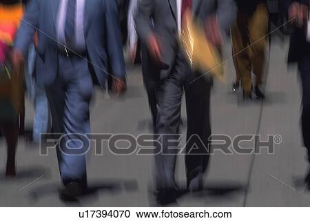 Stock Image - Business people walking down on street, front view, blurred motion, New York City, NY, USA. Fotosearch