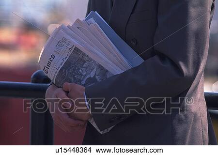 Businessman holding newspapers, side view, close up, New York City, NY, USA View Large Photo Image Picture - Businessman holding newspapers, side view, close up, New York City, NY, USA. Fotosearch