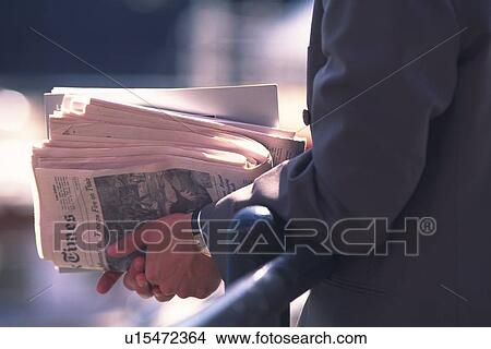 Businessman holding newspapers, side view, close up, New York City, NY, USA View Large Photo Image Picture - Businessman holding newspapers, side view, close up, New York City, NY, USA. Fotosearch